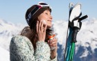 Skifahrerin cremt sich ihr Gesicht ein