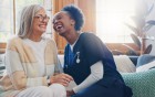 Eine Pflegekraft und eine ältere Dame, die gemeinsam lachen.