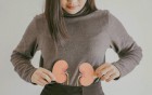 Eine Frau, die mit ihren Händen nierenförmige Figuren hält.
