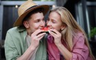 Pärchen teilt sich ein Stück Wassermelone.