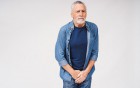 Ein älterer Mann hält sich mit schmerzverzerrtem Gesicht den Intimbereich