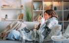 Frau krank auf dem Sofa mit Tee