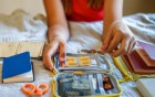  Person packt eine Reiseapotheke mit Medikamenten