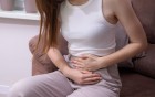 Frau hält sich den Unterleib wegen Schmerzen