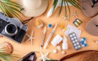Reiseutensilien und Medikamente auf orangefarbenem Hintergrund.